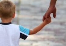 Son holding father's hand